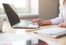 Tlamedia.dk giver din hjemmeside drift og support, så du ikke skal tænke på det Kvinde arbejder på sin computer med notesbog