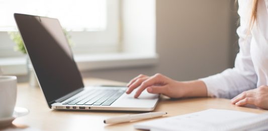 Tlamedia.dk giver din hjemmeside drift og support, så du ikke skal tænke på det Kvinde arbejder på sin computer med notesbog