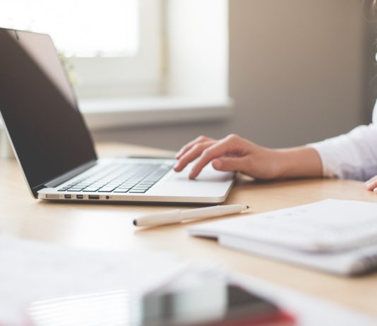 Tlamedia.dk giver din hjemmeside drift og support, så du ikke skal tænke på det Kvinde arbejder på sin computer med notesbog