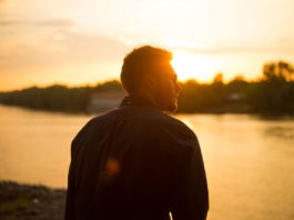 Billig-hårtransplantation tilbyder hårtransplantationer til halvdelen af prisen i Danmark Mand står og kigger ud mod solnedgang over sø