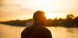 Billig-hårtransplantation tilbyder hårtransplantationer til halvdelen af prisen i Danmark Mand står og kigger ud mod solnedgang over sø