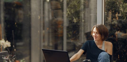 Vil du være sikker på, at din bolig holder i mange år fremover? Så få en vedligeholdelsesplan med SCHØDT Dame sidder med sin bærbar i udestue