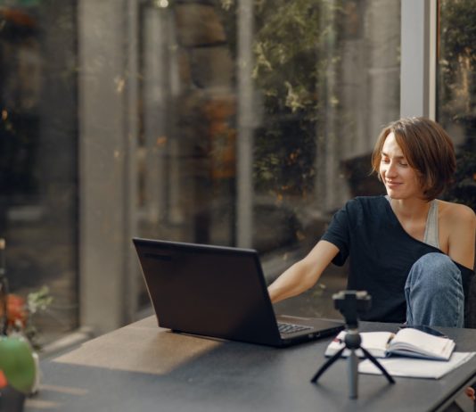 Vil du være sikker på, at din bolig holder i mange år fremover? Så få en vedligeholdelsesplan med SCHØDT Dame sidder med sin bærbar i udestue